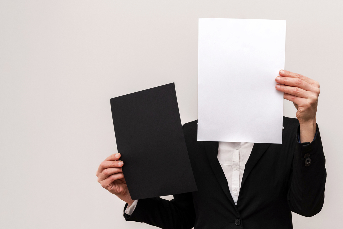Un empresario oculta su rostro tras un papel
