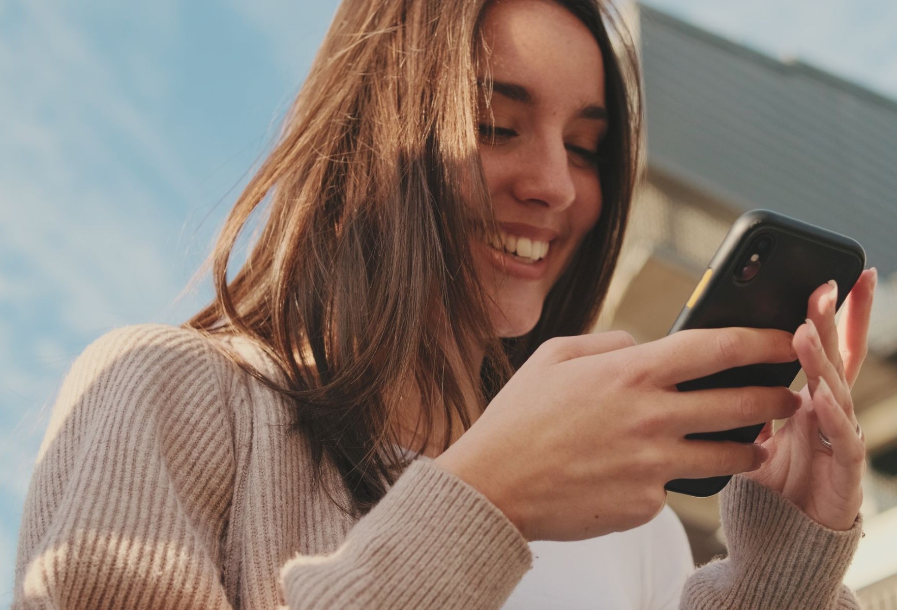 Primer plano de una mujer joven usando un teléfono móvil para comprar en redes sociales