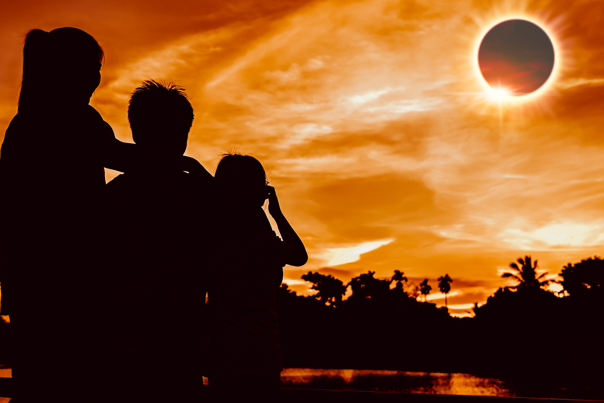 3 personas contemplando un eclipse